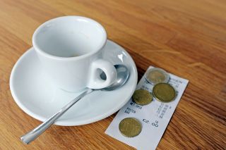 © photophonie - stock.adobe.com Foto: Kaffeetasse mit Rechnung und Münzen